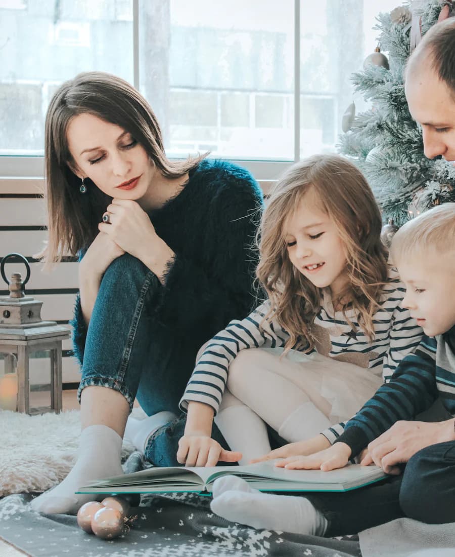 A family reading together beside a Christmas tree